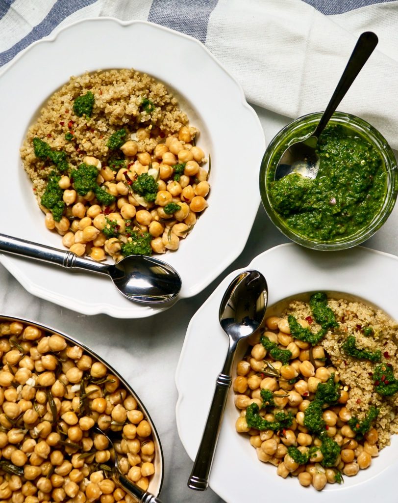 Garbanzo beans with quinoa and chimichurri sauce in white bowls with linen towels