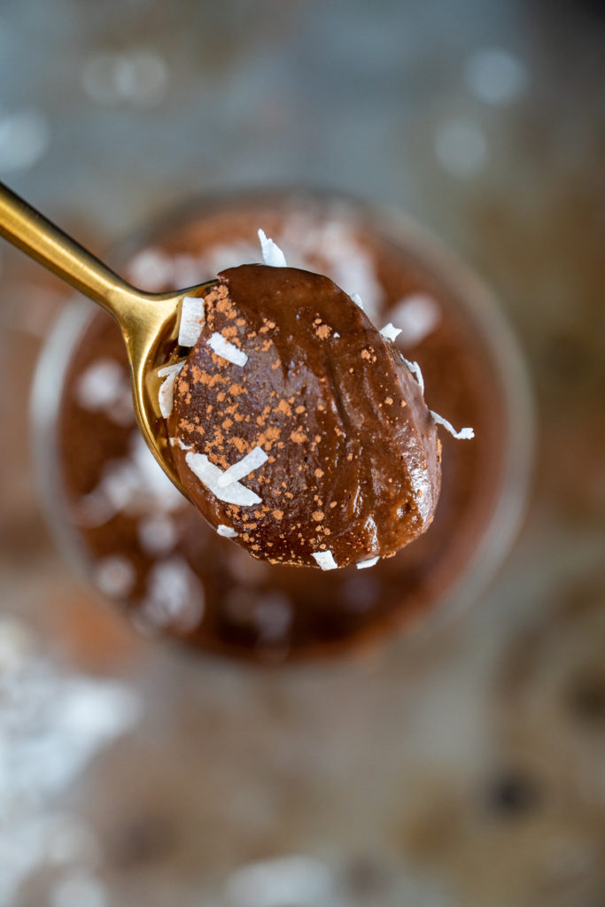 Spoonful of homemade chocolate pudding with coconut flakes