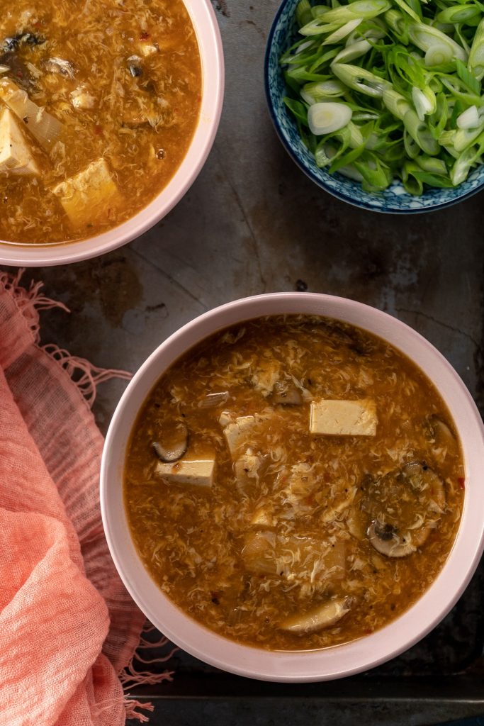 Hot and Sour Soup in bowls with a side of green onions