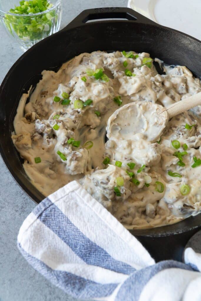 Gluten Free Sausage Gravy in cast iron pan with green onions